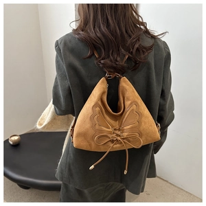 Back view of model wearing a brown suede tote bag with a large butterfly leather patchwork