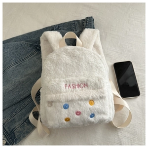 Detail of white plush backpack featuring colorful buttons and fashion embroidery