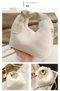 Detail of creamy white faux fur bag showing leather twisted handle and gold logo charm