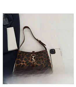 Close-up of leopard print hobo bag featuring a gold piston lock and size comparison