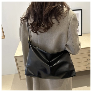 Détail de la boucle en métal doré réglable sur le sac hobo en cuir noir souple