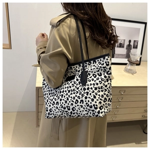 Detail of the leopard print tote bag showing texture and durable leather shoulder straps
