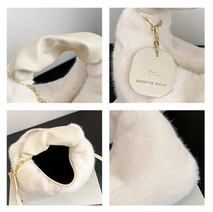 Detail of plush faux fur bag featuring ruched handle and engraved leather tag