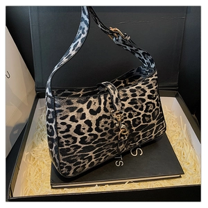 Macro detail of leopard print leather handbag with gold metal clasp in a gift box