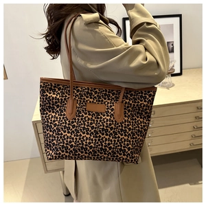 Close-up of leopard print tote bag with brown leather handles in a modern lifestyle setting
