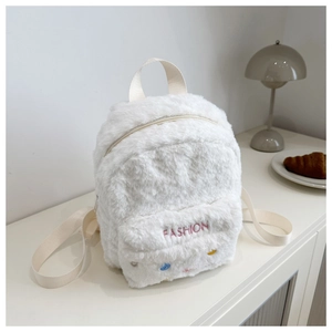 Close-up of white plush backpack with pink FASHION embroidery and soft fuzzy texture