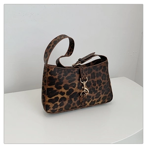 Detailed close-up of leopard print shoulder bag featuring a gold metal buckle closure