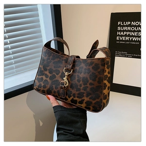 Detail of leopard print small square bag with metallic gold clasp and handle