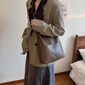 Retro dark brown large capacity faux leather bucket bag shown on a female model