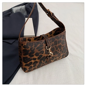 Close-up of leopard print baguette bag with gold metal buckle and textured fabric