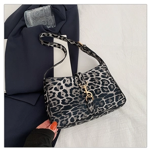 Detailed close-up of leopard print hobo bag with a shiny golden metal lobster clasp
