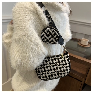 Detail of houndstooth crossbody bag with a detachable coin purse and gold hardware