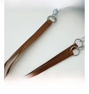 Detail of brown leather handle and thick silver chain on large tote shoulder bag