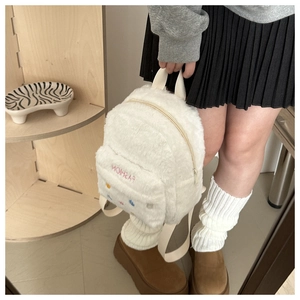 Detail of white plush mini backpack with pink Fashion embroidery and colorful polka dots