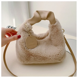 Détail du sac d'hiver en peluche avec poignée nouée et étiquette à chaîne dorée