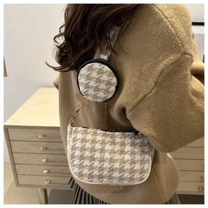 Detail of houndstooth crossbody bag set with mini pouch shown on a model