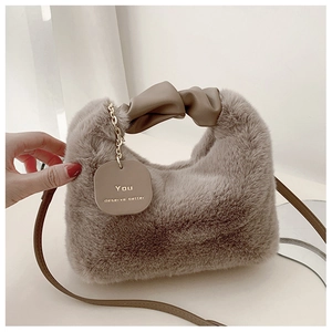 Détail de la texture en fausse fourrure pelucheuse du sac kaki avec poignée à nœud chic