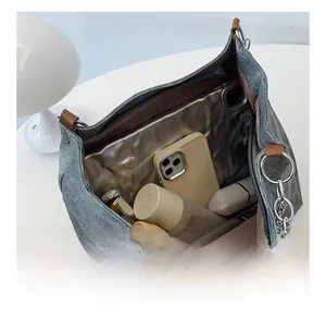 Detailed interior of gray denim tote bag showing spacious capacity and brown leather strap