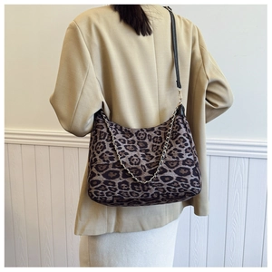 Detail view of the leopard print shoulder bag with a gold chain and black leather strap