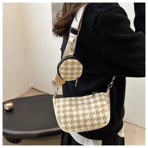 Detail of houndstooth crossbody bag with round pouch and adjustable canvas strap