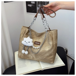 Detail of khaki canvas tote with chain strap, pearl beads and plush cloud charm