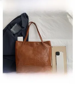 Size comparison of brown crocodile pattern tote bag with tablet and daily essentials