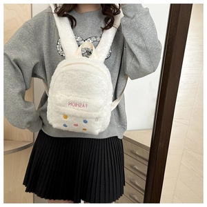 Detail of white plush backpack featuring colorful smile buttons and FASHION embroidery