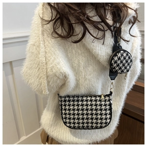 Detail of houndstooth shoulder bag set with round pouch and gold metal hardware