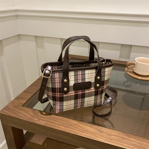 Pink and brown plaid tote bag with faux leather handles on a wooden coffee table