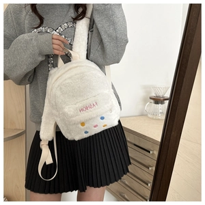 Detail of white faux fur mini backpack featuring colorful dots and fashion embroidery