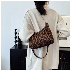 Detail of leopard print fabric texture and metal chain strap on women's shoulder bag