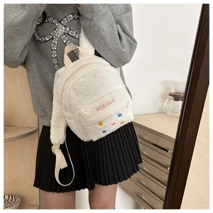 Detailed macro view of white plush mini backpack featuring colorful buttons and fashion embroidery