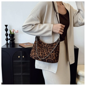 Detail of leopard print shoulder bag with gold chain and adjustable brown leather strap