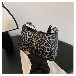 Detail of leopard print handbag featuring structured design and gold clasp closure