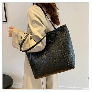 Macro shot of black embossed crocodile texture on a large capacity tote shoulder bag