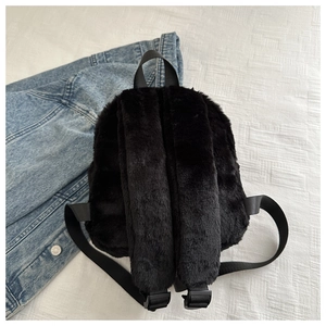 Close-up of black fuzzy backpack showing plush faux fur texture and adjustable straps