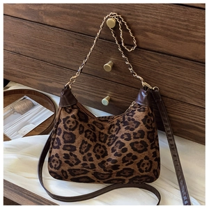 Detail of leopard print hobo bag with gold metal chain and brown leather shoulder strap