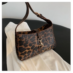 Close-up of leopard print shoulder bag with golden lobster clasp and leather texture