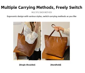 Detail view of large crocodile pattern tote bag in brown showing shoulder and hand-carry styles