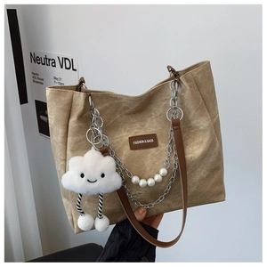 Detail of khaki canvas tote with leather straps, chain and cloud pearl pendant