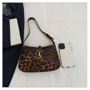 Macro detail of leopard print shoulder bag featuring a signature gold buckle closure