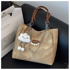 Detail of light coffee tote bag featuring silver chain, white pearls and cloud charm