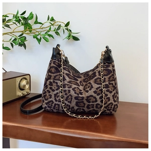 Detailed close-up of leopard print shoulder bag on a vintage wooden table with radio