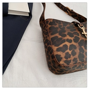 Detail view of leopard print texture and gold hardware on trendy shoulder bag