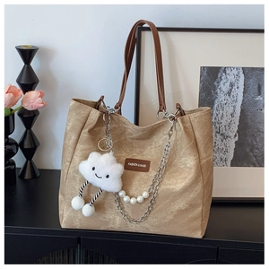 Detail of khaki tote bag featuring wrinkled texture, pearl chain and cloud charm deco