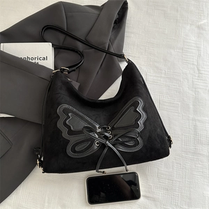 Large black suede bucket tote bag with leather butterfly knot and metal eyelet details