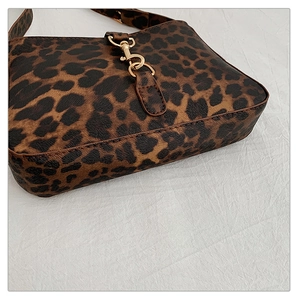 Detail of leopard print handbag with premium golden lobster clasp and leather texture