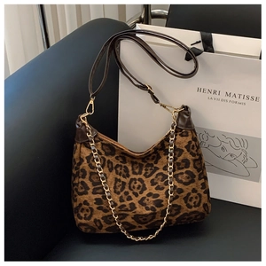 Close-up of leopard print shoulder bag with gold chain and leather strap on seat