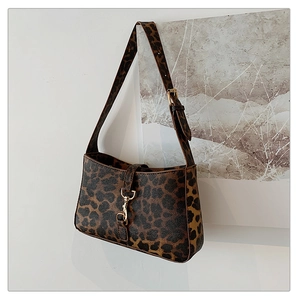 Detail of leopard print shoulder bag with gold metal clasp and adjustable strap