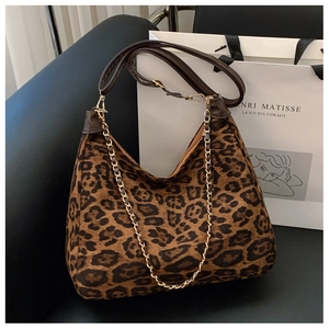 Detail of leopard print hobo bag with gold metal chain and brown leather strap